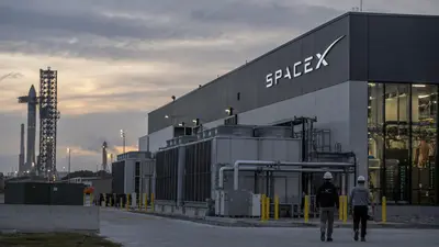 SpaceX launch facility with a Starship tower at dusk, workers walking past